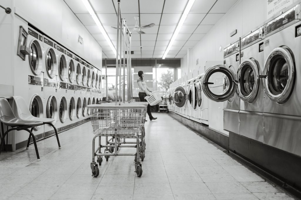 row of washing machines and dryers at laundromat 